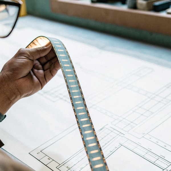 Person holding LED strip over blueprint (ID#1)