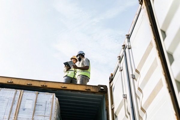 Workers inspecting shipping container outdoors (ID#4)