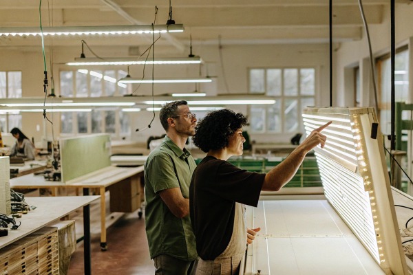 Two people inspecting large LED panel in workshop (ID#4)