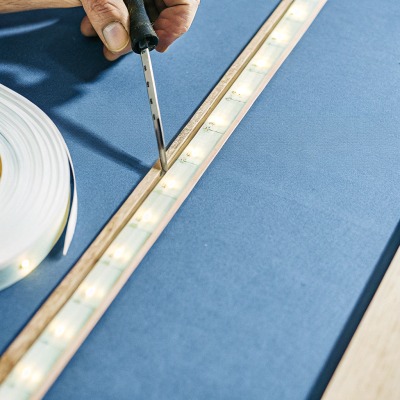 Technician performing a gentle pull test on LED strip wires